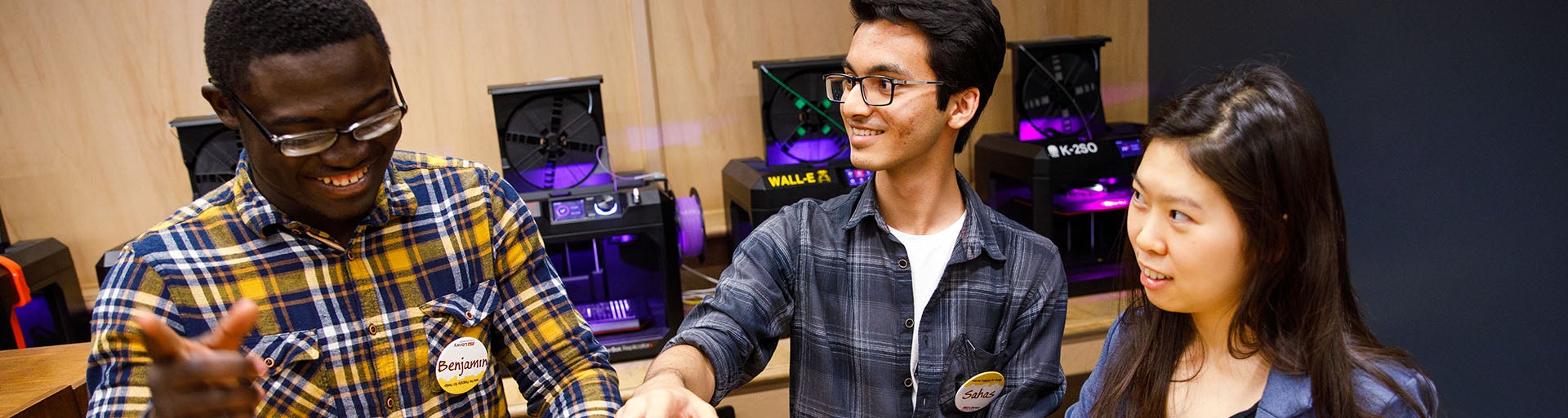 Three international students having a conversation in a computer lab