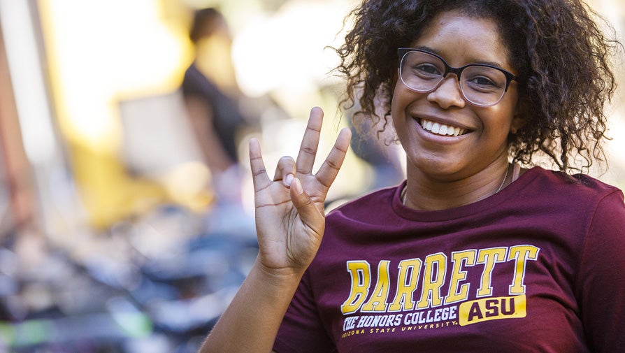 Barrett student wearing maroon shirt showing pitchfork symbol