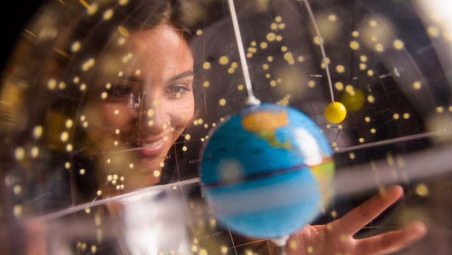 Student looking at a globe