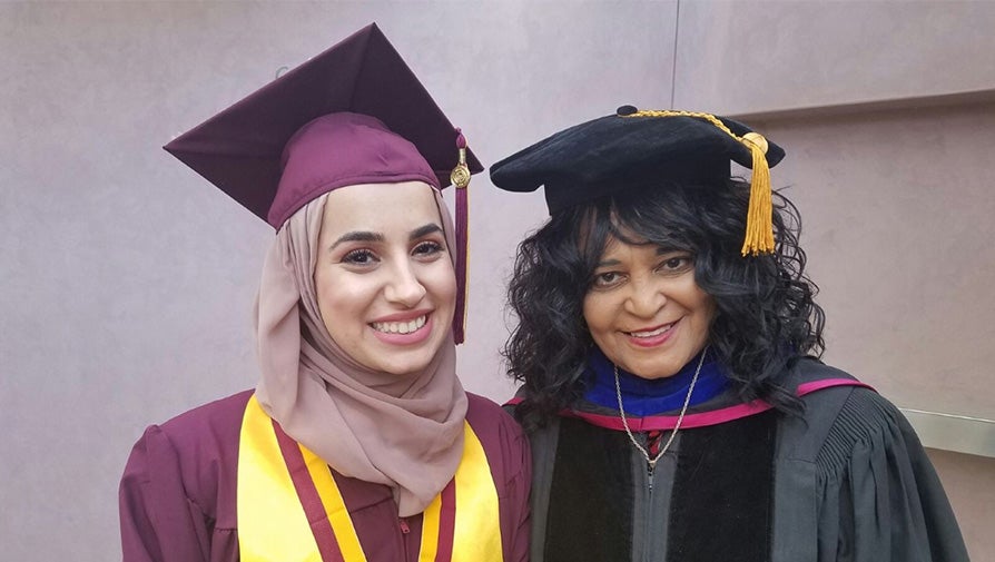 Faculty Honors Advisor with a student at graduation